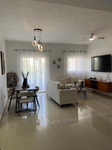 un soggiorno con un divano e un tavolo di Modern 2BR Condo Near the Beach Juan Dolio a Villas del Mar