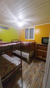 a room with two bunk beds and a tv at Hospedaje con Pensión Completa in Angol