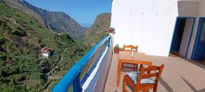 Un balcón con mesa y sillas mirando a las montañas. en Oiá Paúl, en Paul 8 fotos más