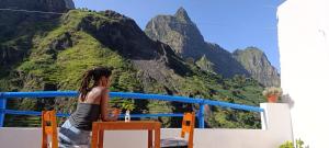 una mujer sentada en un bote mirando las montañas en Oiá Paúl, en Paul