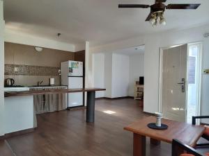 a kitchen with a table and a ceiling fan at Hornero House in San Antonio de Areco