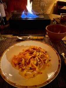 un piatto di pasta su un tavolo davanti al fuoco di Chalé Mirante da Serra a Sabará