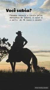 Un uomo che cavalca un cavallo in un campo di Chalé Mirante da Serra a Sabará