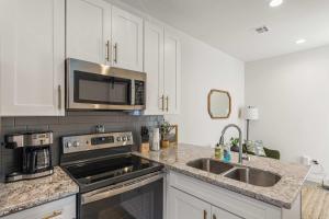 a kitchen with a sink and a microwave at Charming Townhome - New Construction in Lafayette +13 photos