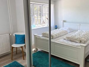 une chambre avec un lit avec un miroir et une chaise dans l'établissement 4 person holiday home in Hanstholm-By Traum, à Hanstholm