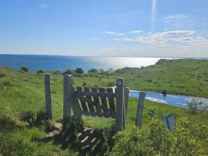 uma cerca de madeira na grama perto de um corpo d'água em 16 person holiday home in Vejby em Vejby