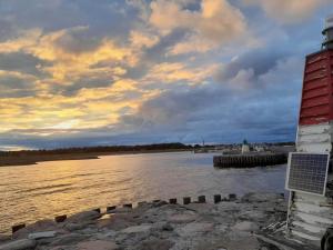 une vue d'un plan d'eau avec un phare dans l'établissement 26 person holiday home in Grenaa, à Grenå