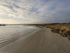 une plage de sable avec un bateau dans l'eau dans l'établissement 26 person holiday home in Grenaa, à Grenå