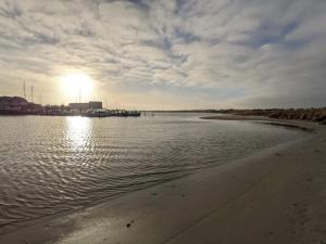une masse d'eau avec le soleil en arrière-plan dans l'établissement 26 person holiday home in Grenaa, à Grenå 42 autres photos