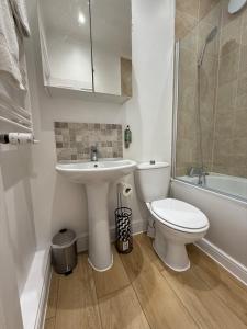 a bathroom with a sink and a toilet and a tub at Spacious 2 Bed & 1 Bath - Close to Beach & City Centre in Brighton & Hove +18 photos