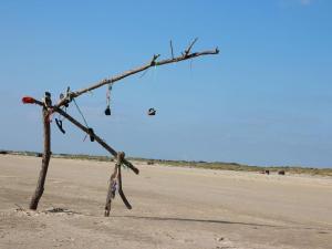 une branche d'arbre avec une paire de chaussures sur une plage dans l'établissement 6 person holiday home in Fanø-By Traum, à Fanø