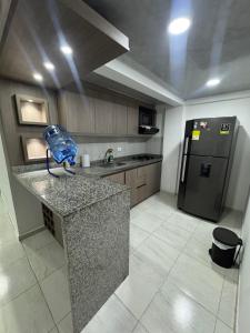 eine Küche mit Theke und Kühlschrank in der Unterkunft Bulevar Santa Rosa, apartamento nuevo y acogedor in Santa Rosa de Cabal + 9 Fotos