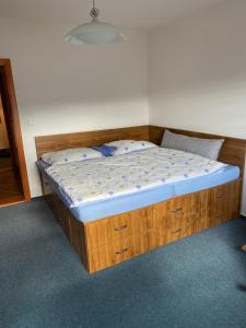 a bed with a wooden frame in a bedroom at Chata u Špičáku in Albrechtice v Jizerských horách