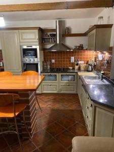 a kitchen with white cabinets and a wooden counter top at Chata u Špičáku in Albrechtice v Jizerských horách +7 photos
