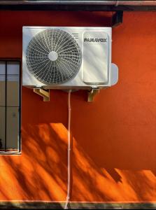 Un ventilateur blanc est fixé à un mur. dans l'établissement Cábañas cielos Del jaure, à Jaureguiberry