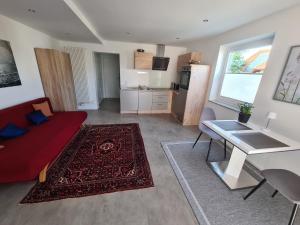 a living room with a red couch and a table at Ferienwohnung Lösel in Freilassing