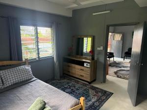 a bedroom with a bed and a dresser and a mirror at The Athaliah Abode in Suva