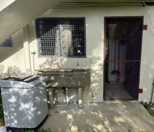 a bathroom with a sink and a window and a trash can at The Athaliah Abode in Suva