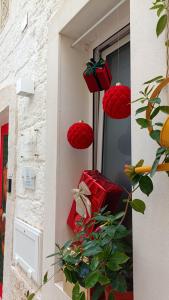 deux paniers rouges suspendus à une fenêtre avec une plante dans l'établissement La Casetta, à Mola di Bari