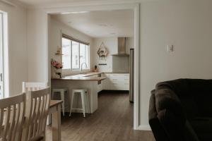 a white kitchen with a sink and a counter at Marsden Manor - Spacious house with large pool in Greymouth