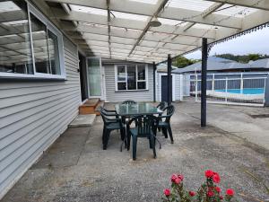 a patio with a table and chairs on it at Marsden Manor - Spacious house with large pool in Greymouth