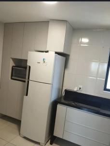 kuchnia z białą lodówką w pokoju w obiekcie Apê da Rê w mieście João Pessoa