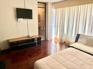 una habitación de hotel con una cama y un televisor en Lima Mini Aparts Monterrico - Cerca Embajada EEUU, en Lima
