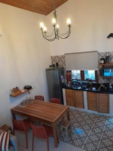 a kitchen with a wooden table and a refrigerator at Chalé Colibri in Vale do Capao
