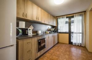 eine Küche mit Holzschränken und einer weißen Mikrowelle in der Unterkunft Guest House Intrigue in Cherven