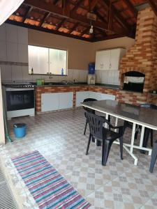 a large kitchen with a table and chairs in it at Chalé da Vovó Neusa in Socorro