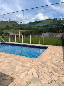 a swimming pool in front of a fence at Chalé da Vovó Neusa in Socorro
