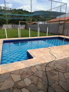 a swimming pool with a hose on the ground at Chalé da Vovó Neusa in Socorro +2 photos