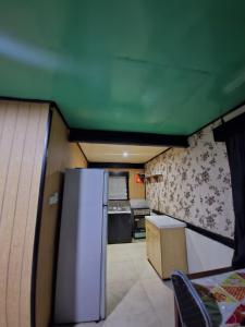 een keuken met een koelkast en een groen plafond bij HeightsVille Transit in Port Moresby