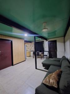 een woonkamer met groene plafonds en een bank bij HeightsVille Transit in Port Moresby