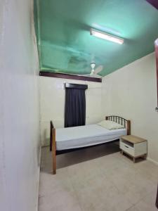 een kleine kamer met een bed en een tafel bij HeightsVille Transit in Port Moresby