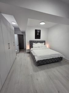 a bedroom with a large bed in a white room at Sya House in Craiova