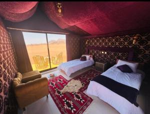 Un dormitorio con dos camas y una gran ventana. en Rum Night Style, en Wadi Rum