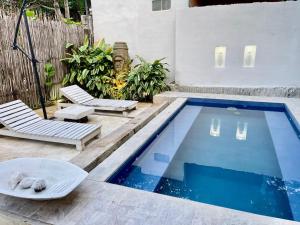 una piscina con dos tumbonas y una piscina en Casa Kai, en Palomino