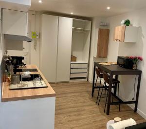 a small kitchen with a table and a counter top at Studio cosy, proche Bordeaux et fleuve in Lormont