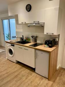 a kitchen with a sink and a stove top oven at Studio cosy, proche Bordeaux et fleuve in Lormont