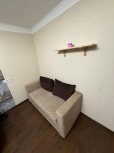 eine Couch in einem Zimmer mit Regal an der Wand in der Unterkunft Alans Place to visit in Daugavpils