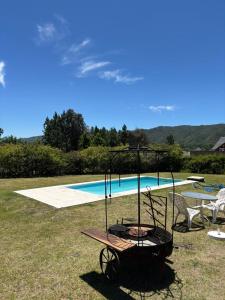 a cart sitting in front of a swimming pool at La Macarena Suites in Villa General Belgrano