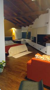 a large room with two beds and a television at La Macarena Suites in Villa General Belgrano