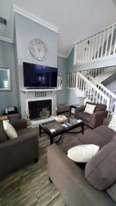 Una sala de estar con sofás y un reloj en la pared. en Jenkins Cove Getaway, en Tybee Island