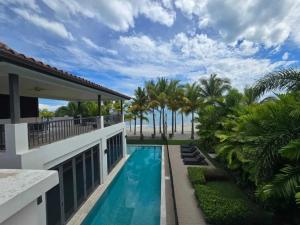 Una vista de una casa con piscina y palmeras. en Elegant Villa, en Los Destiladeros