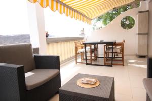 a living room with a table and chairs on a patio at Sonja Apartman in Mogán