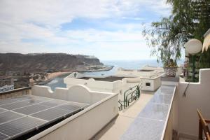a view from the balcony of a house with solar panels at Sonja Apartman in Mogán