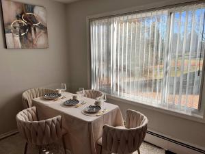 une salle à manger avec une table et des chaises et une fenêtre dans l'établissement Modern 1BR Porchlight retreat, à Farmington Hills