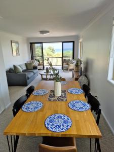 a dining room with a table with four plates on it at Beachfront Bliss in Lennox Head