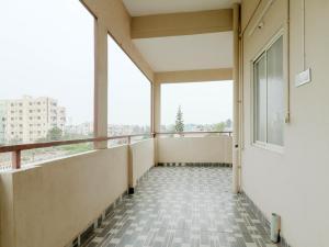 un balcon vide d'un bâtiment avec une grande fenêtre dans l'établissement Hotel O Sea Coastal Inn, à Kakinada 33 autres photos